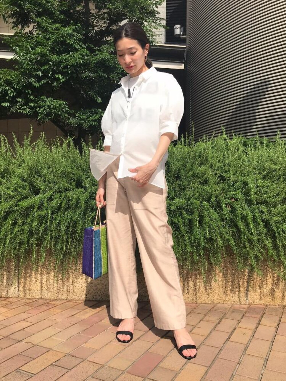 ベージュ系のその他パンツ、ホワイト系のシャツ/ブラウス、ブラック系のサンダルを着用したレディースの夏コーディネートの1枚目の写真