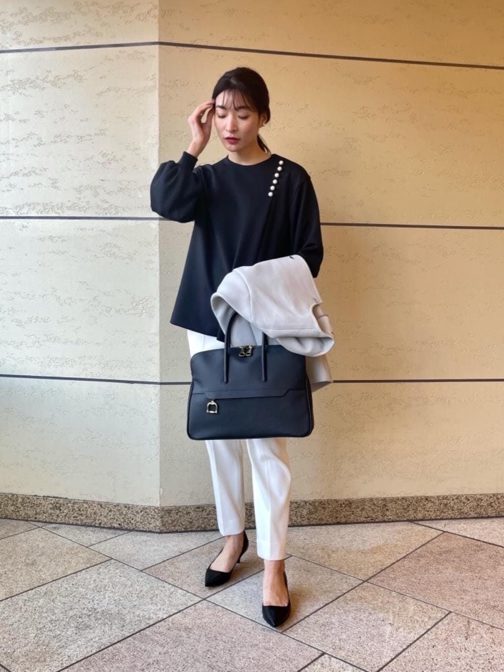 ブルー系のビジネスバッグ、グレー系のその他アウター、ブルー系のシャツ/ブラウスを着用したレディースの冬コーディネートの1枚目の写真