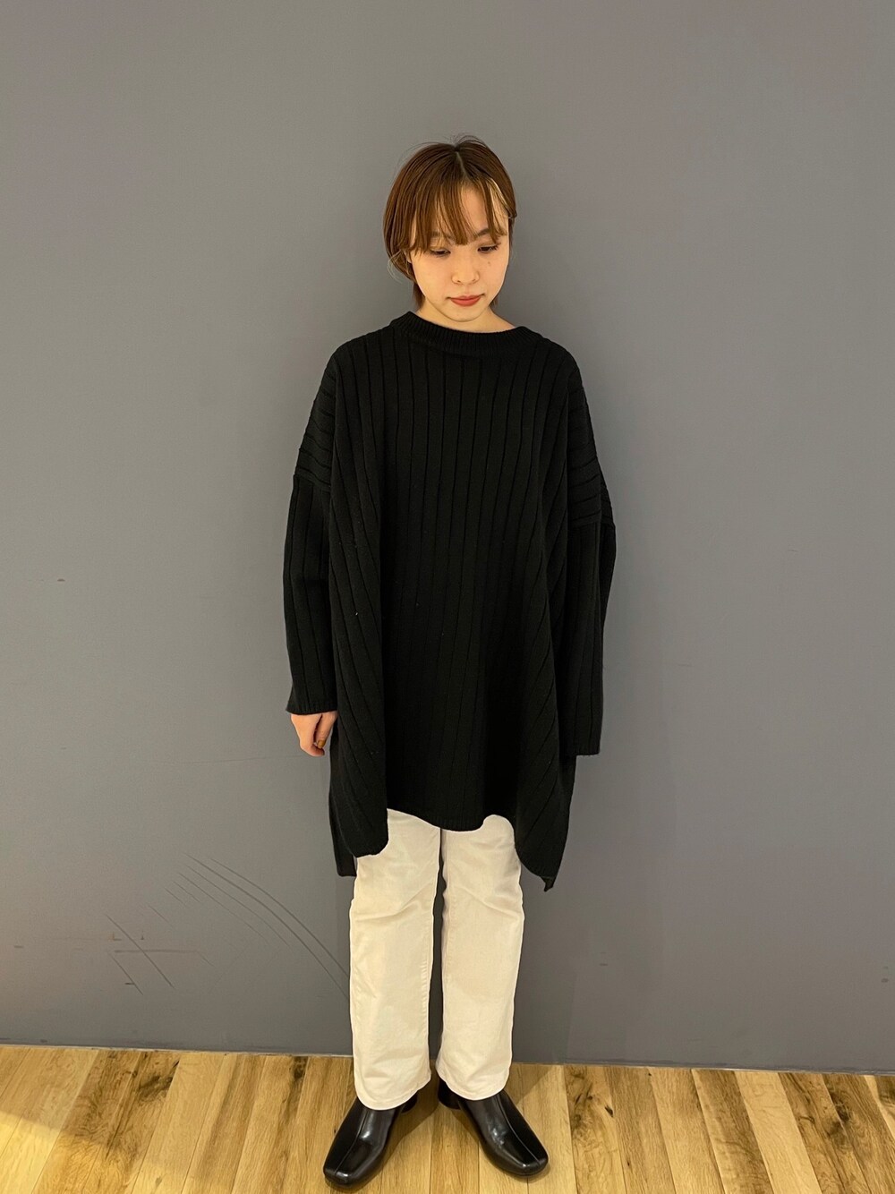 ブラック系のニット/セーター、ホワイト系のその他パンツ、ブラック系のブーツを着用したレディースの秋コーディネートの1枚目の写真