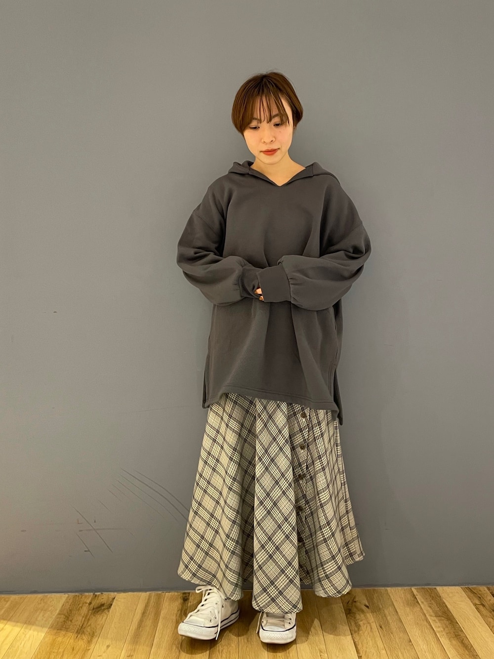 グレー系のパーカー、ホワイト系のスカートを着用したレディースの冬コーディネートの1枚目の写真