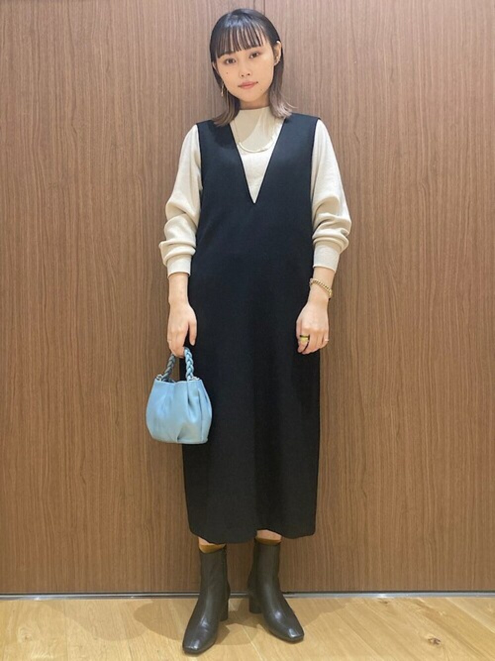 ブルー系のショルダーバッグ、ブラック系のワンピース、ベージュ系のニット/セーターを着用したレディースの秋コーディネートの1枚目の写真