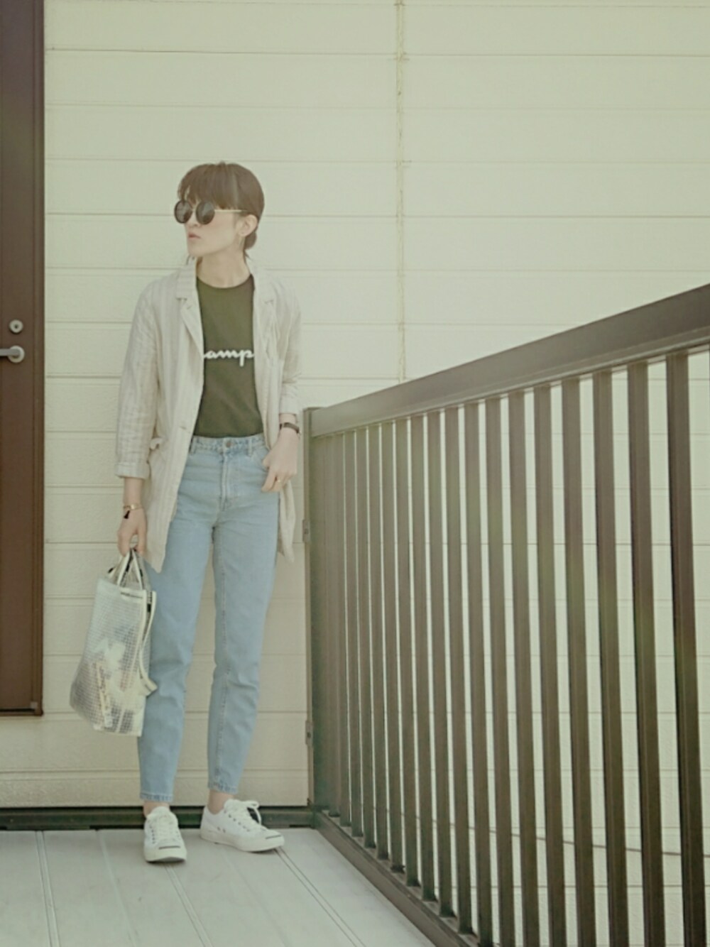 ブラック系のTシャツ/カットソー、ブルー系のデニムパンツ、ホワイト系のトートバッグを着用したレディースの春コーディネートの1枚目の写真