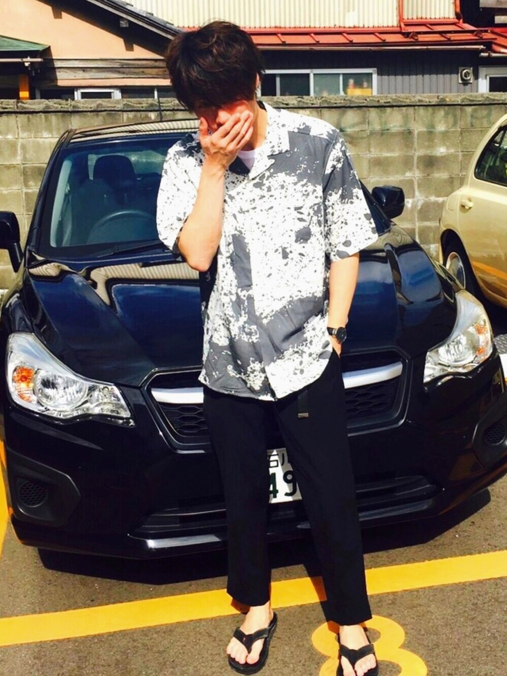 ブラック系のスラックス、ホワイト系のシャツ/ブラウス、ブラック系のサンダルを着用したメンズの夏コーディネートの1枚目の写真