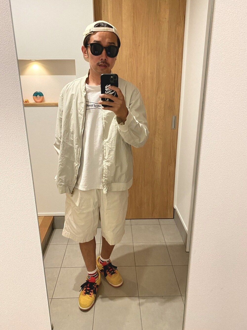 ベージュ系のブルゾン、ホワイト系のTシャツ/カットソー、ベージュ系のその他パンツを着用したメンズの春コーディネートの1枚目の写真