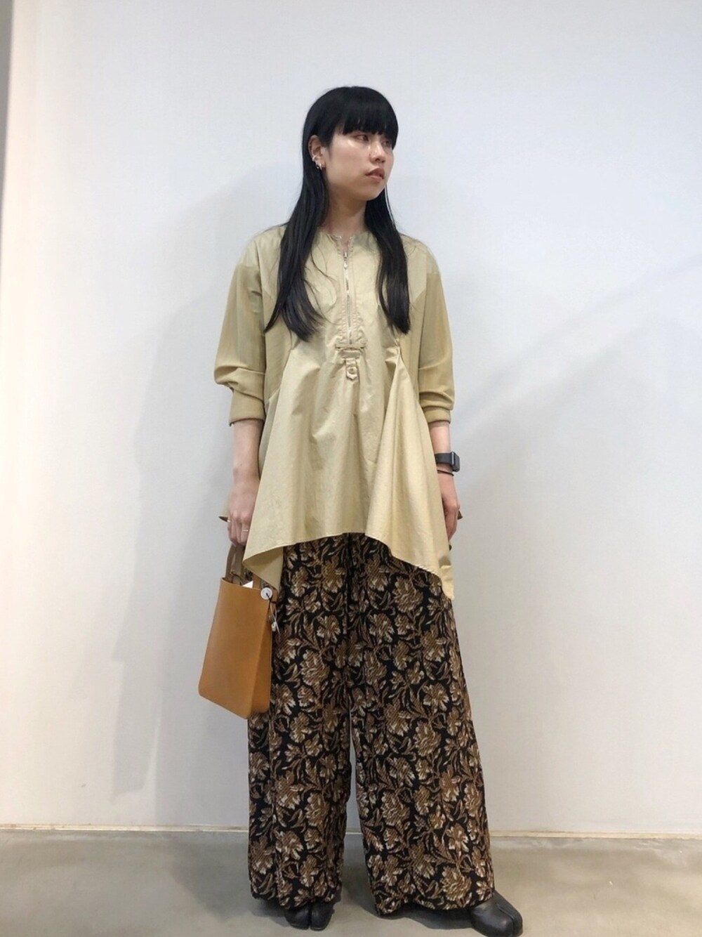 ベージュ系のショルダーバッグ、ベージュ系のシャツ/ブラウス、ブラック系のその他パンツを着用したレディースの秋コーディネートの1枚目の写真