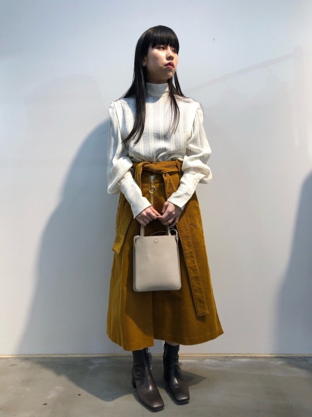 ホワイト系のシャツ/ブラウス、ベージュ系のショルダーバッグ、ブラウン系のブーツを着用したレディースの冬コーディネートの1枚目の写真