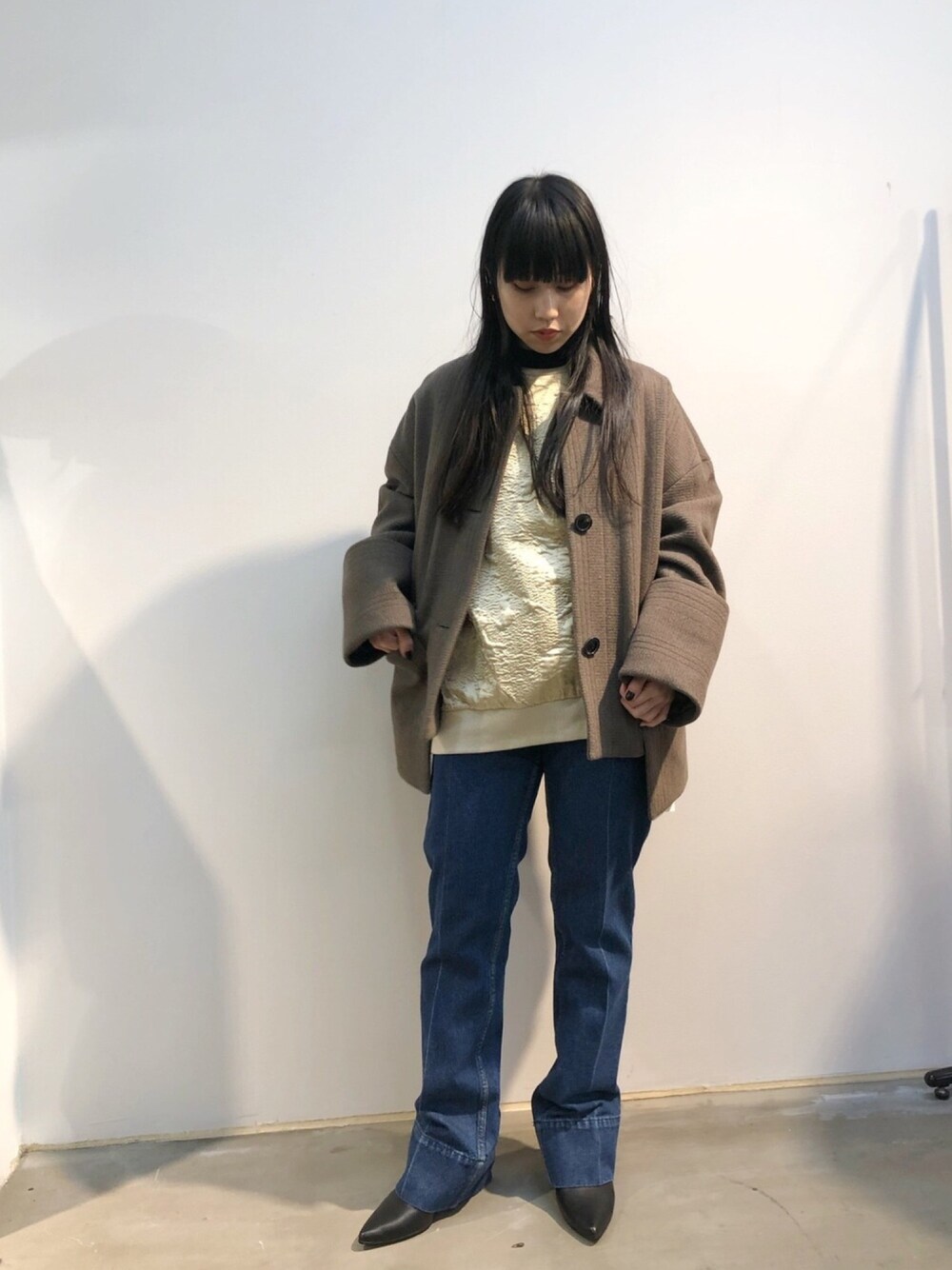 ホワイト系のスウェット、ブルー系のデニムパンツ、ブラウン系のその他アウターを着用したレディースの冬コーディネートの1枚目の写真