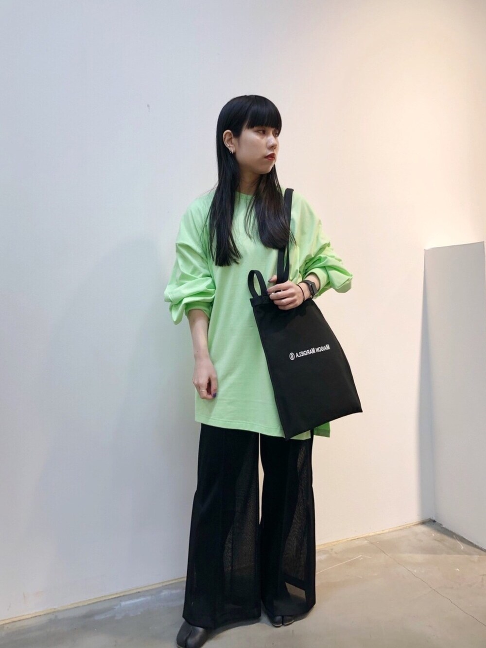ブラック系のその他パンツ、ブラック系のトートバッグ、グリーン系のトップスを着用したレディースの冬コーディネートの1枚目の写真