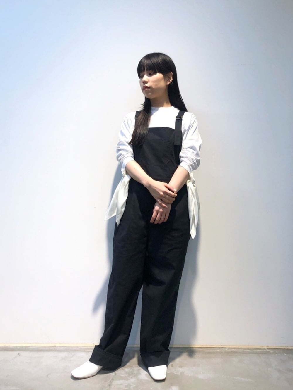 ホワイト系のTシャツ/カットソー、ブラック系のサロペット/オーバーオール、ホワイト系のパンプスを着用したレディースの春コーディネートの1枚目の写真