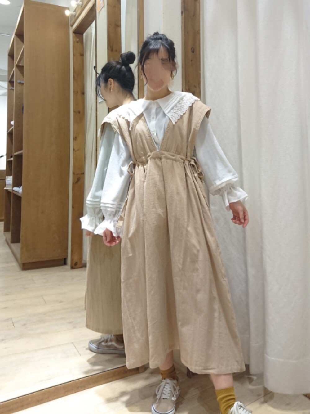 ベージュ系のジャンパースカート、ホワイト系のシャツ/ブラウスを着用したレディースの春コーディネートの1枚目の写真