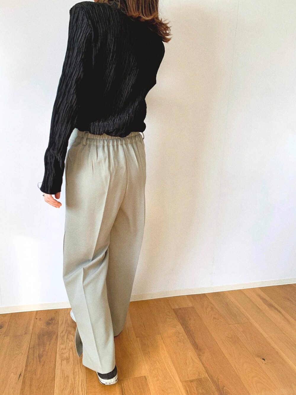 グリーン系のパンツ、ブラック系のトップスを着用したレディースの夏コーディネートの1枚目の写真
