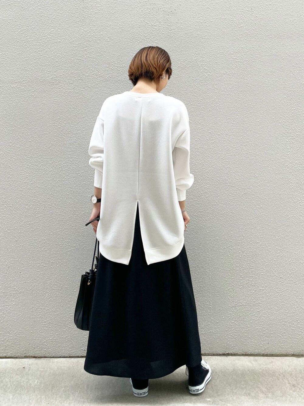 ホワイト系のスウェット、ブラック系のスカート、ブラック系のショルダーバッグを着用したレディースの冬コーディネートの1枚目の写真