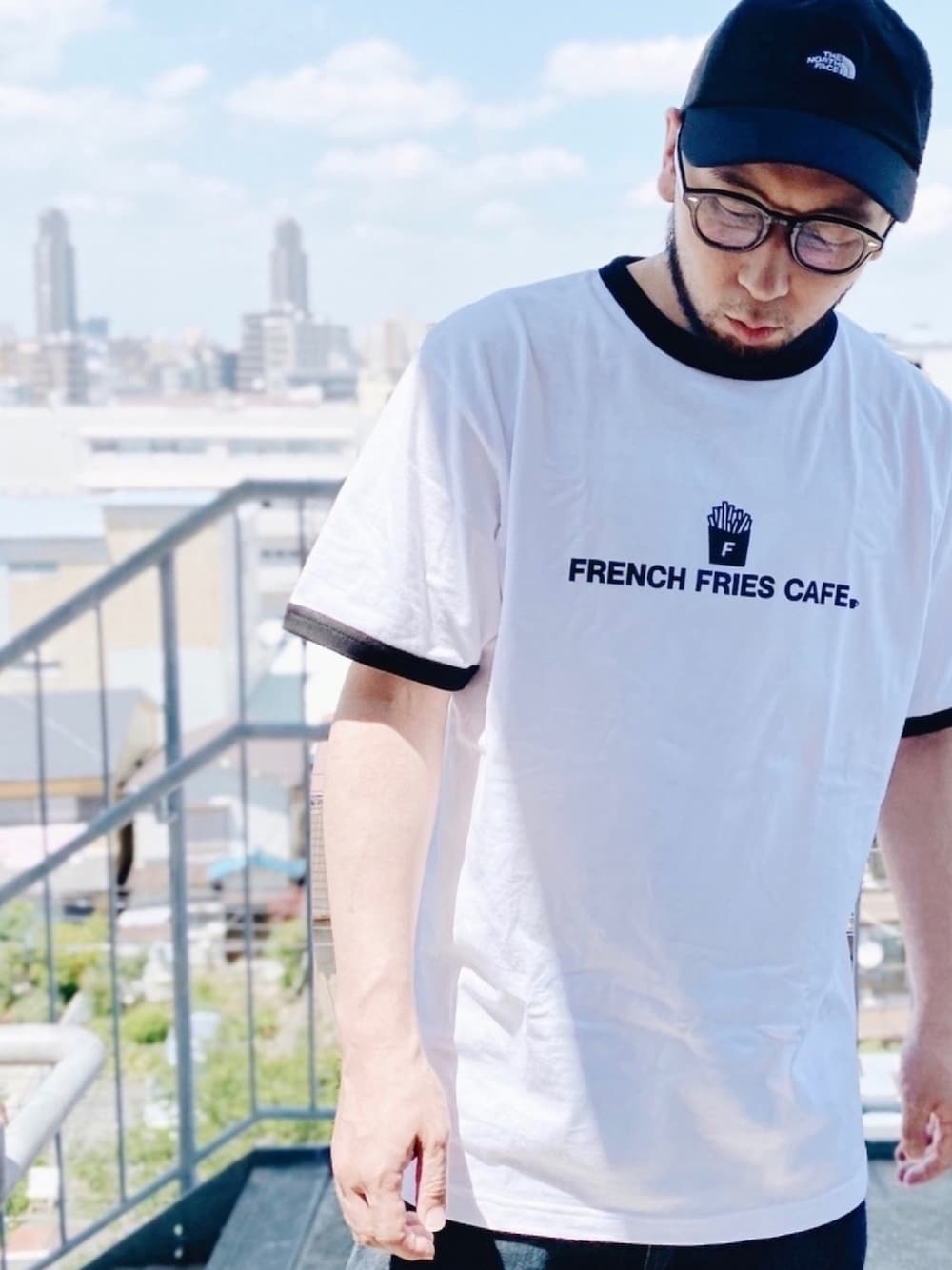 ホワイト系のTシャツ/カットソー、ブルー系のデニムパンツ、ブラック系のサンダルを着用したメンズの夏コーディネートの1枚目の写真