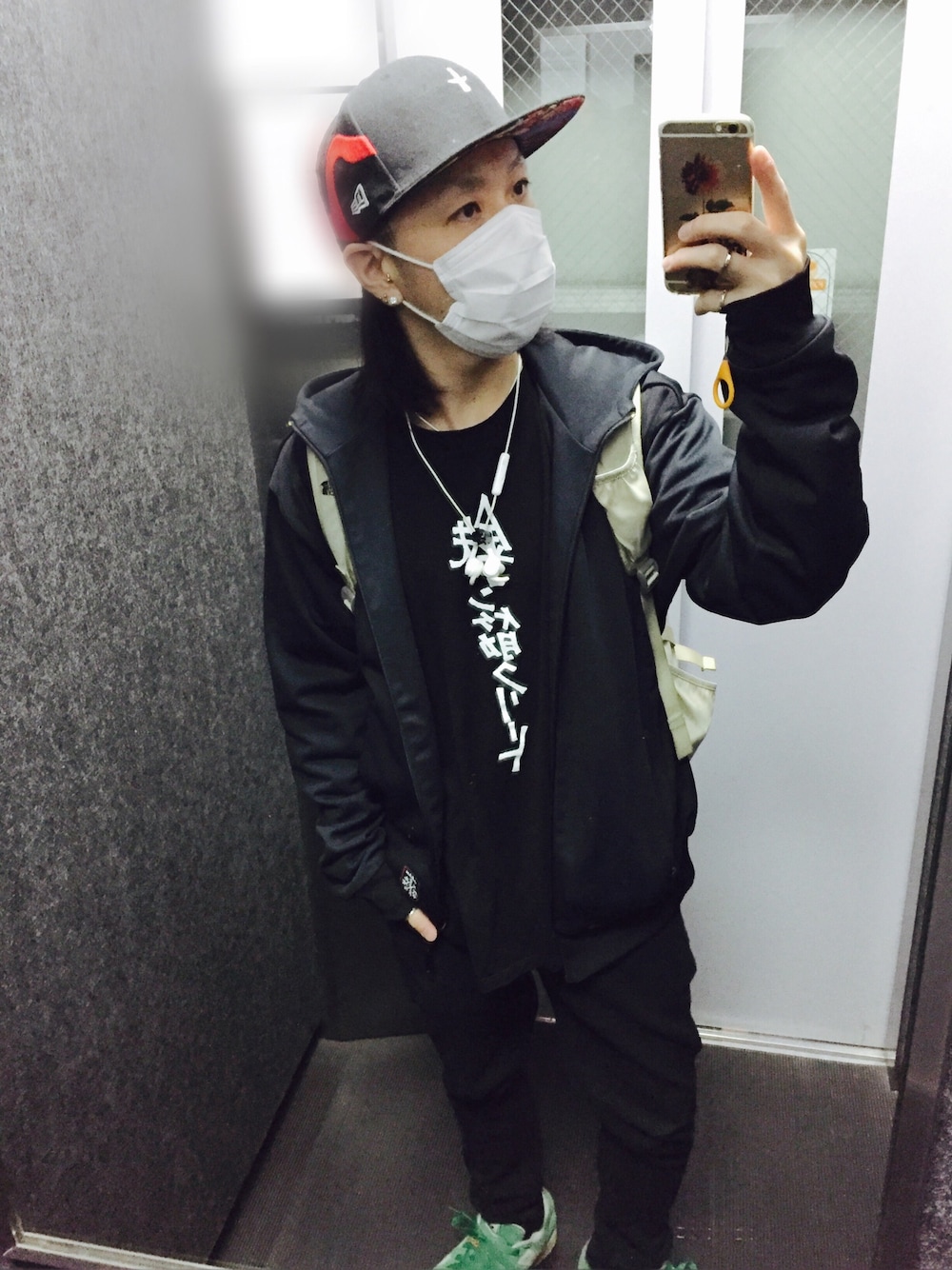 グリーン系のスニーカー、ブラック系のチノパンツ、ブラック系のTシャツ/カットソーを着用したメンズの春コーディネートの1枚目の写真