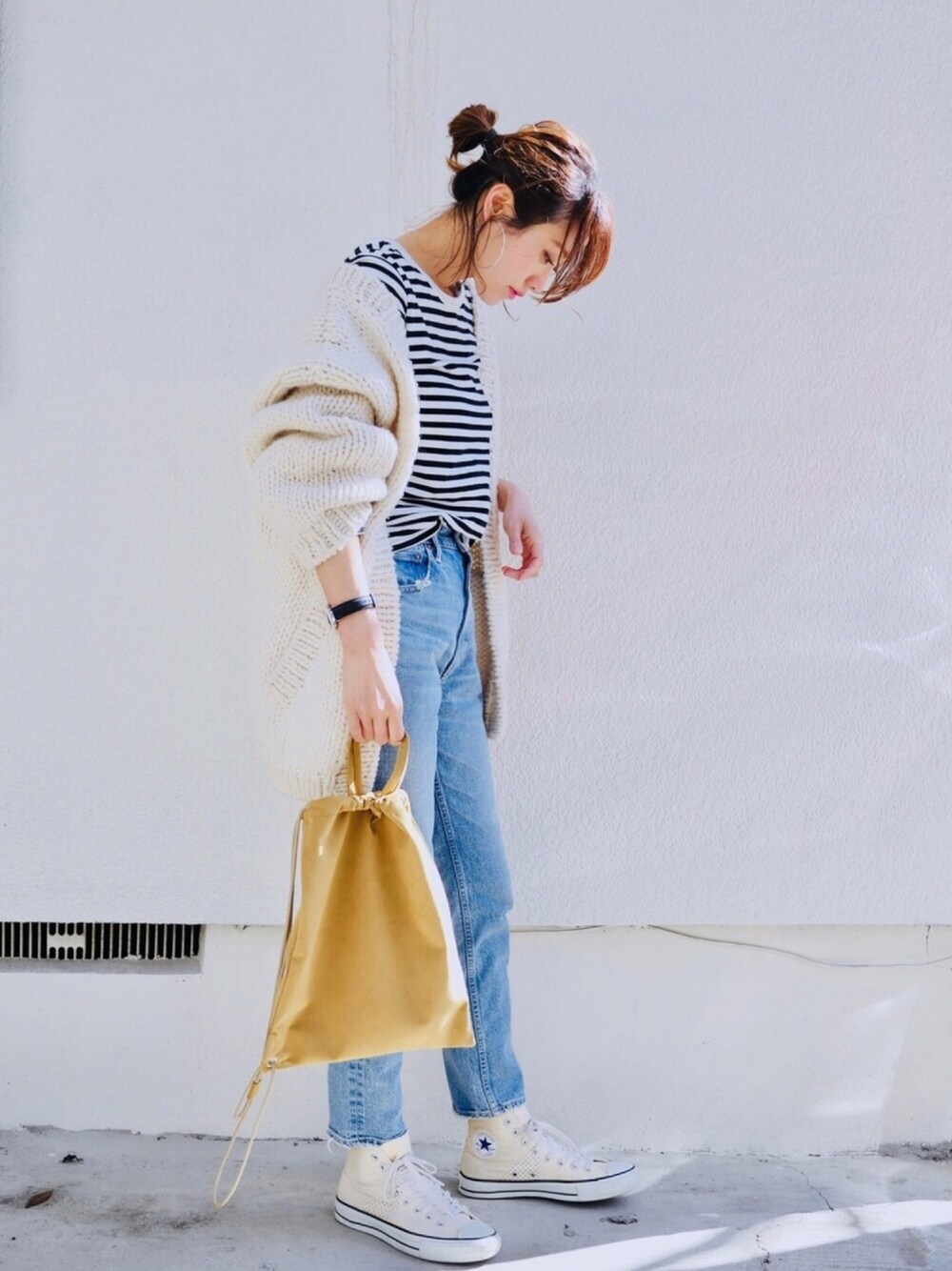 ブラック系のTシャツ/カットソー、ホワイト系のカーディガン/ボレロ、ブルー系のデニムパンツを着用したレディースの春コーディネートの1枚目の写真