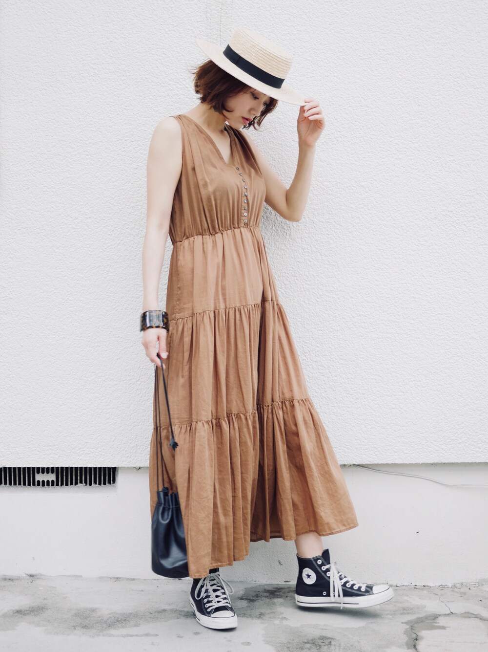 イエロー系のワンピース、その他のショルダーバッグ、ブラック系のスニーカーを着用したレディースの夏コーディネートの1枚目の写真