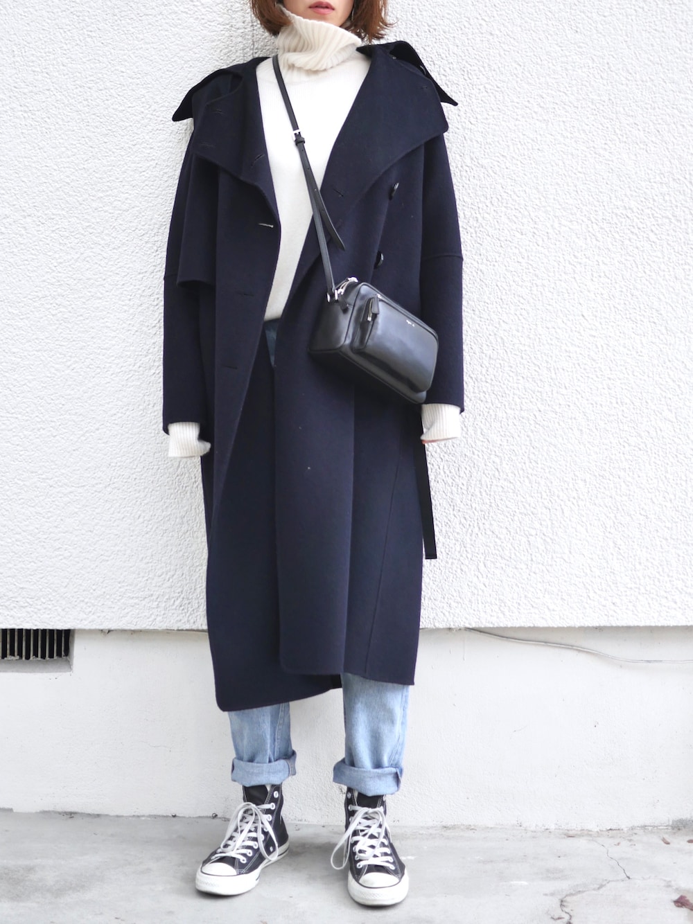 ホワイト系のニット/セーター、ブルー系のデニムパンツ、ブルー系のトレンチコートを着用したレディースの冬コーディネートの1枚目の写真