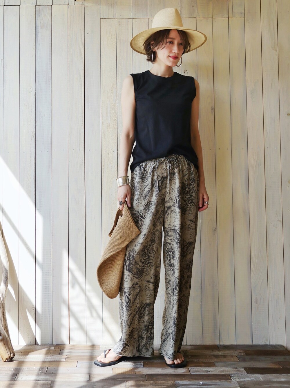 その他のタンクトップ、グレー系のその他パンツ、ベージュ系のかごバッグを着用したレディースの夏コーディネートの1枚目の写真