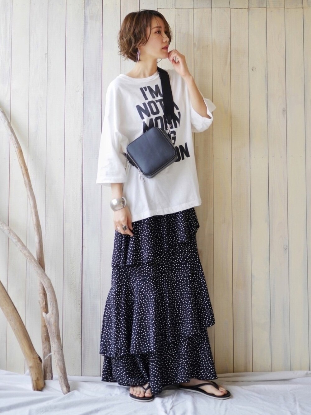 ホワイト系のTシャツ/カットソー、ブラック系のスカート、ブラック系のショルダーバッグを着用したレディースの春コーディネートの1枚目の写真