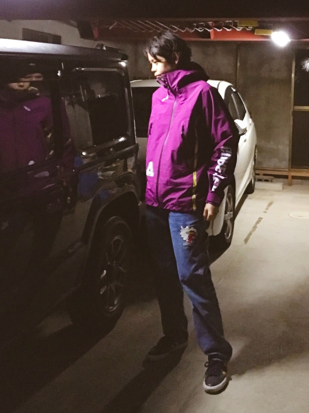 パープル系のマウンテンパーカー、ブルー系のデニムパンツ、ブルー系のスニーカーを着用したメンズの冬コーディネートの1枚目の写真