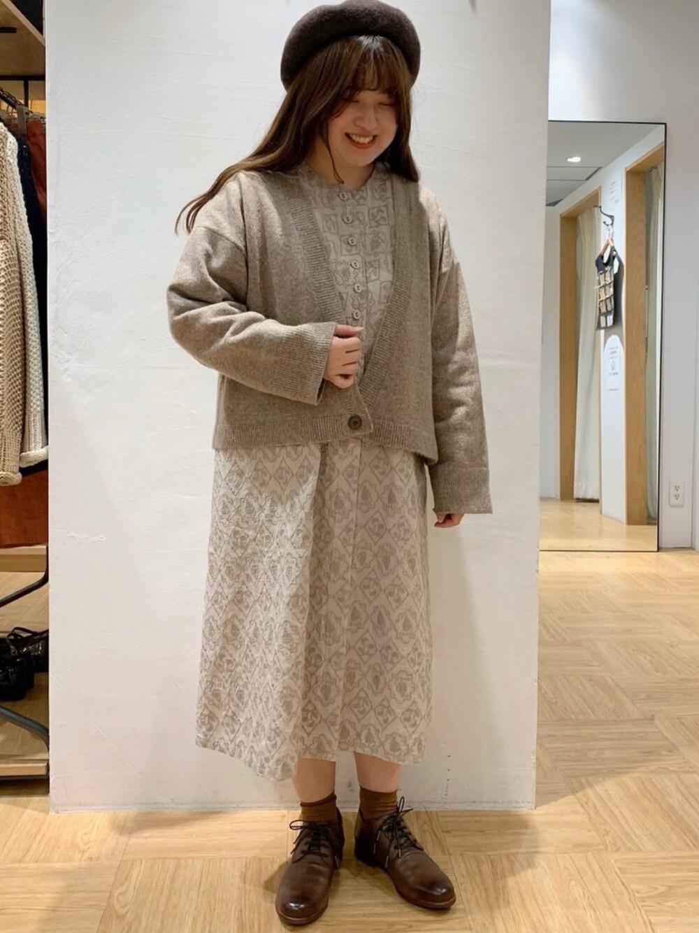 ベージュ系のカーディガン/ボレロ、ベージュ系のワンピース、ブラウン系のドレスシューズを着用したレディースの秋コーディネートの1枚目の写真