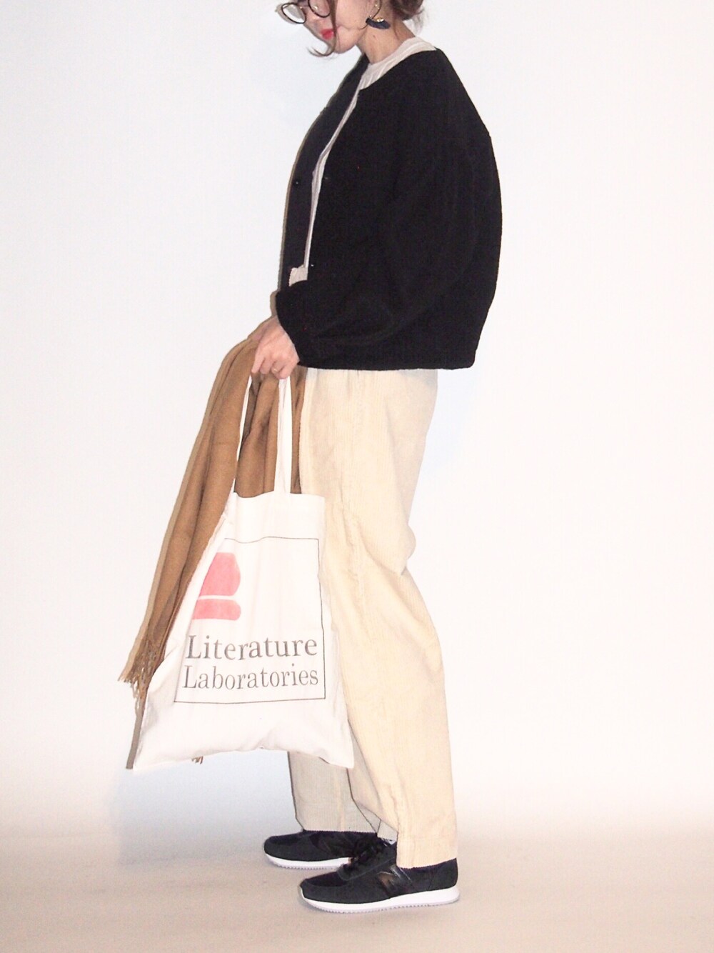 ブラック系のブルゾン、ホワイト系のニット/セーター、ホワイト系のトートバッグを着用したレディースの秋コーディネートの1枚目の写真