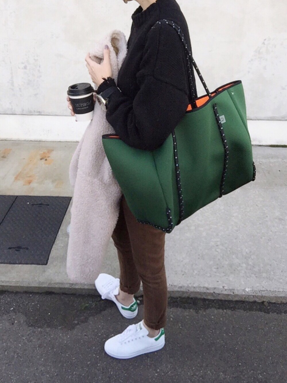 ブラック系のニット/セーター、ベージュ系のノーカラージャケット、ブラウン系のデニムパンツを着用したレディースの冬コーディネートの1枚目の写真