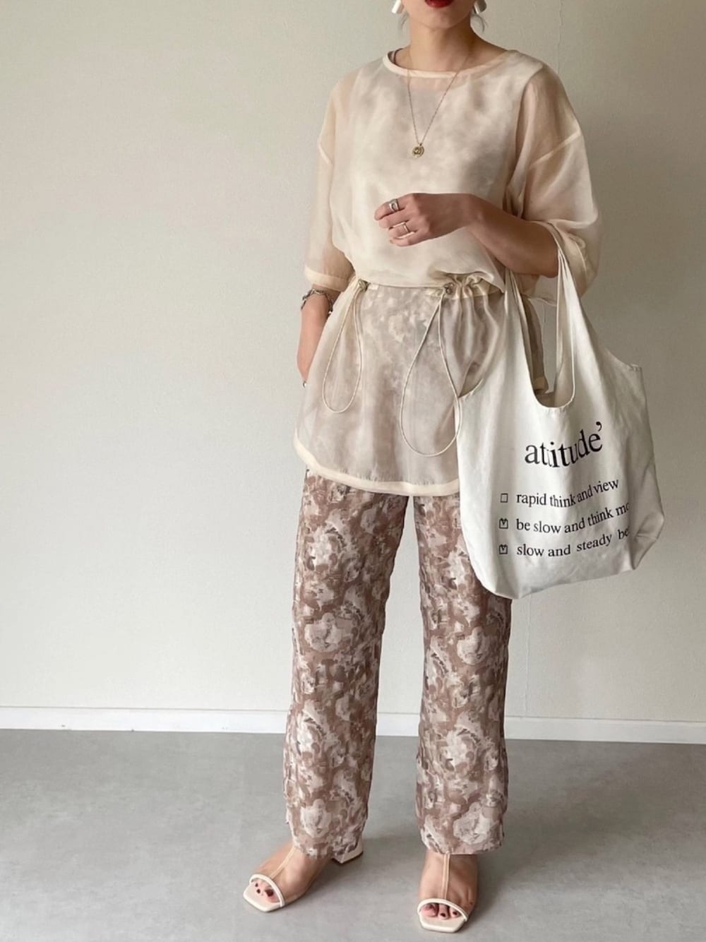 ベージュ系のその他パンツ、ホワイト系のサンダル、ホワイト系のシャツ/ブラウスを着用したレディースの春コーディネートの1枚目の写真