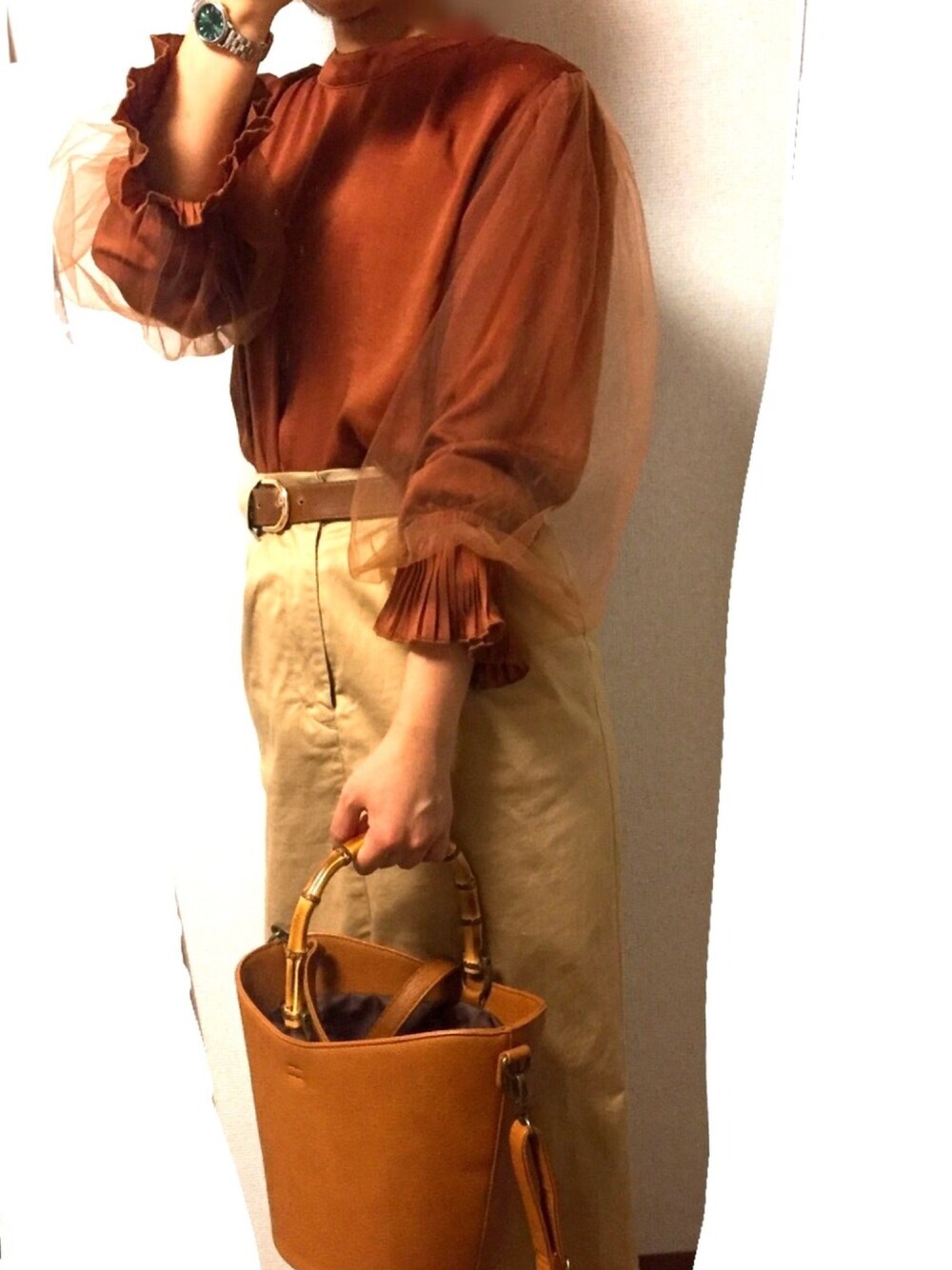 ブラウン系のシャツ/ブラウス、ベージュ系のスカート、ブラウン系のハンドバッグを着用したレディースの秋コーディネートの1枚目の写真