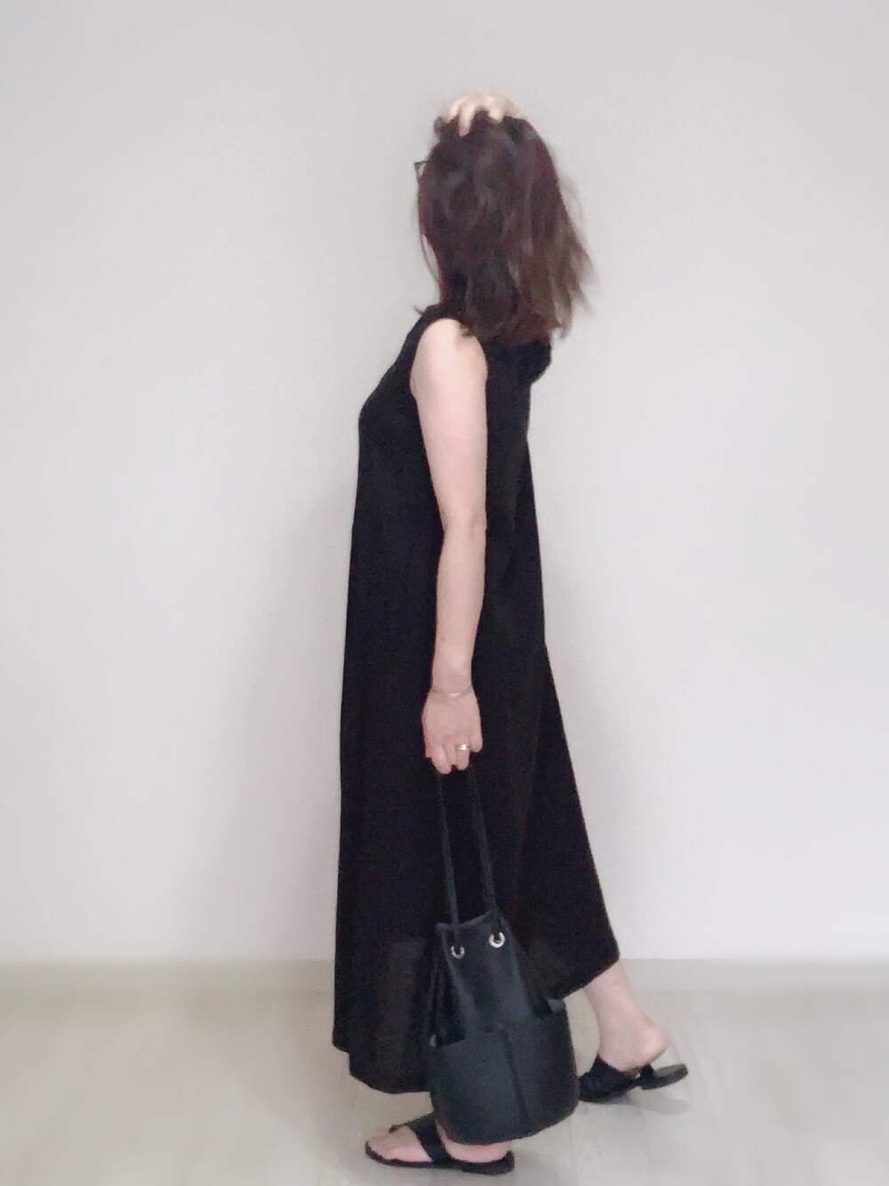 ブラック系のワンピース、ブラック系のショルダーバッグ、シルバー系のリングを着用したレディースの夏コーディネートの1枚目の写真