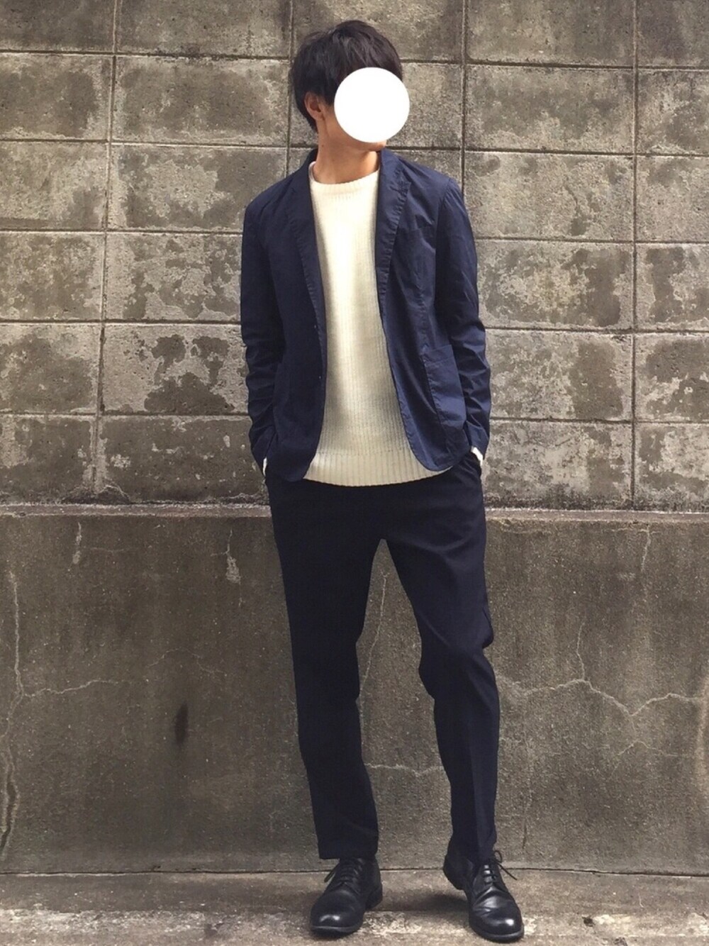 ホワイト系のニット/セーター、ブルー系のスラックス、ブラック系のドレスシューズを着用したメンズの冬コーディネートの1枚目の写真