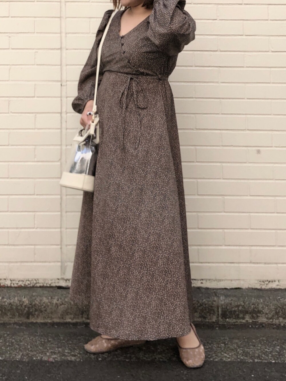 ホワイト系のショルダーバッグ、ブラック系のワンピース、ブラウン系のバレエシューズを着用したレディースの春コーディネートの1枚目の写真