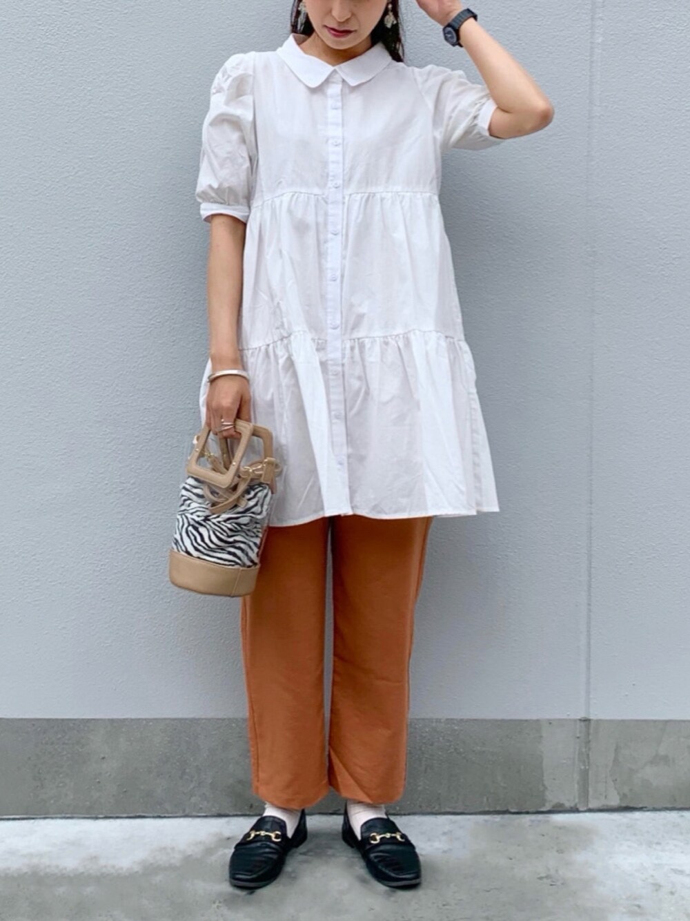 ベージュ系のショルダーバッグ、オレンジ系のその他パンツを着用したレディースの春コーディネートの1枚目の写真