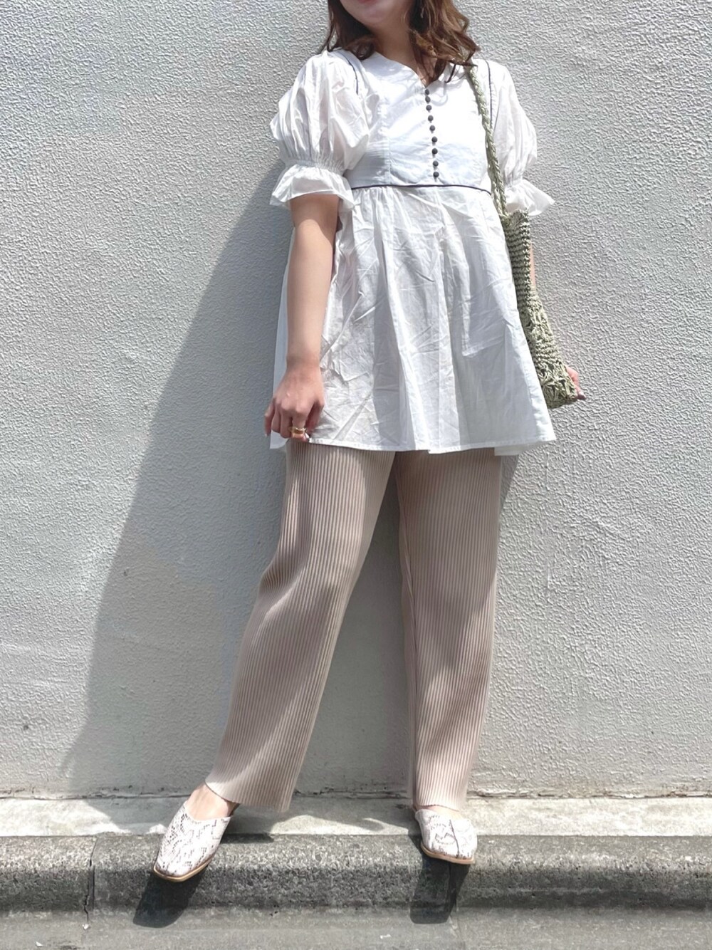 ホワイト系のシャツ/ブラウス、ベージュ系のその他パンツ、グレー系のシューズを着用したレディースの春コーディネートの1枚目の写真