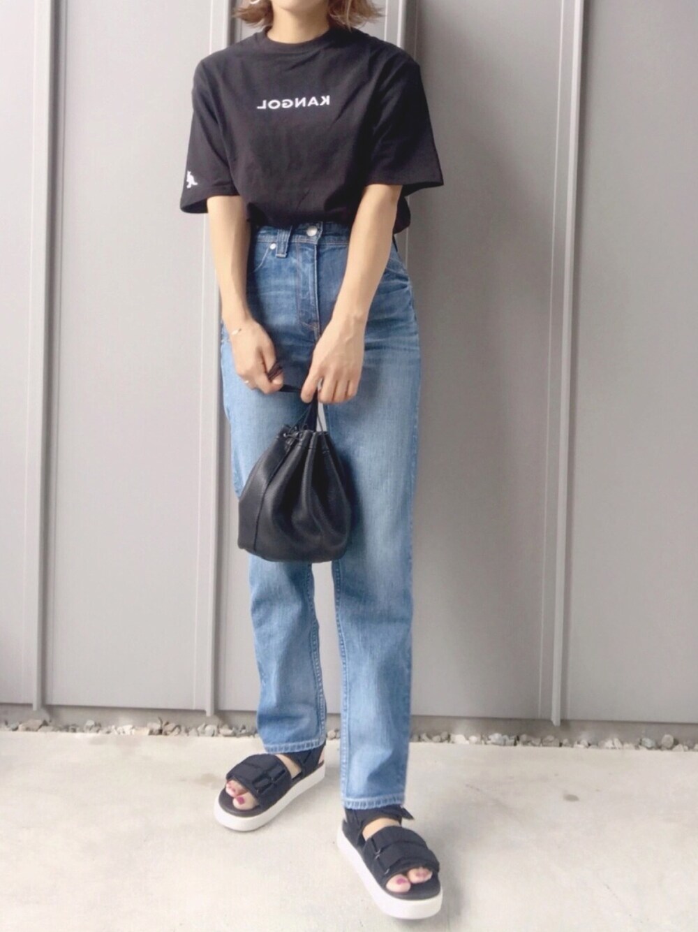 ブラック系のTシャツ/カットソー、ブルー系のデニムパンツ、ホワイト系のサンダルを着用したレディースの夏コーディネートの1枚目の写真