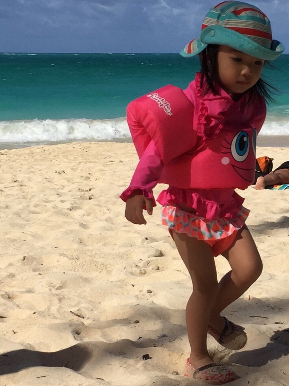 ピンク系の水着、ピンク系のラッシュガード、ピンク系のスイムグッズを着用したキッズの夏コーディネートの1枚目の写真