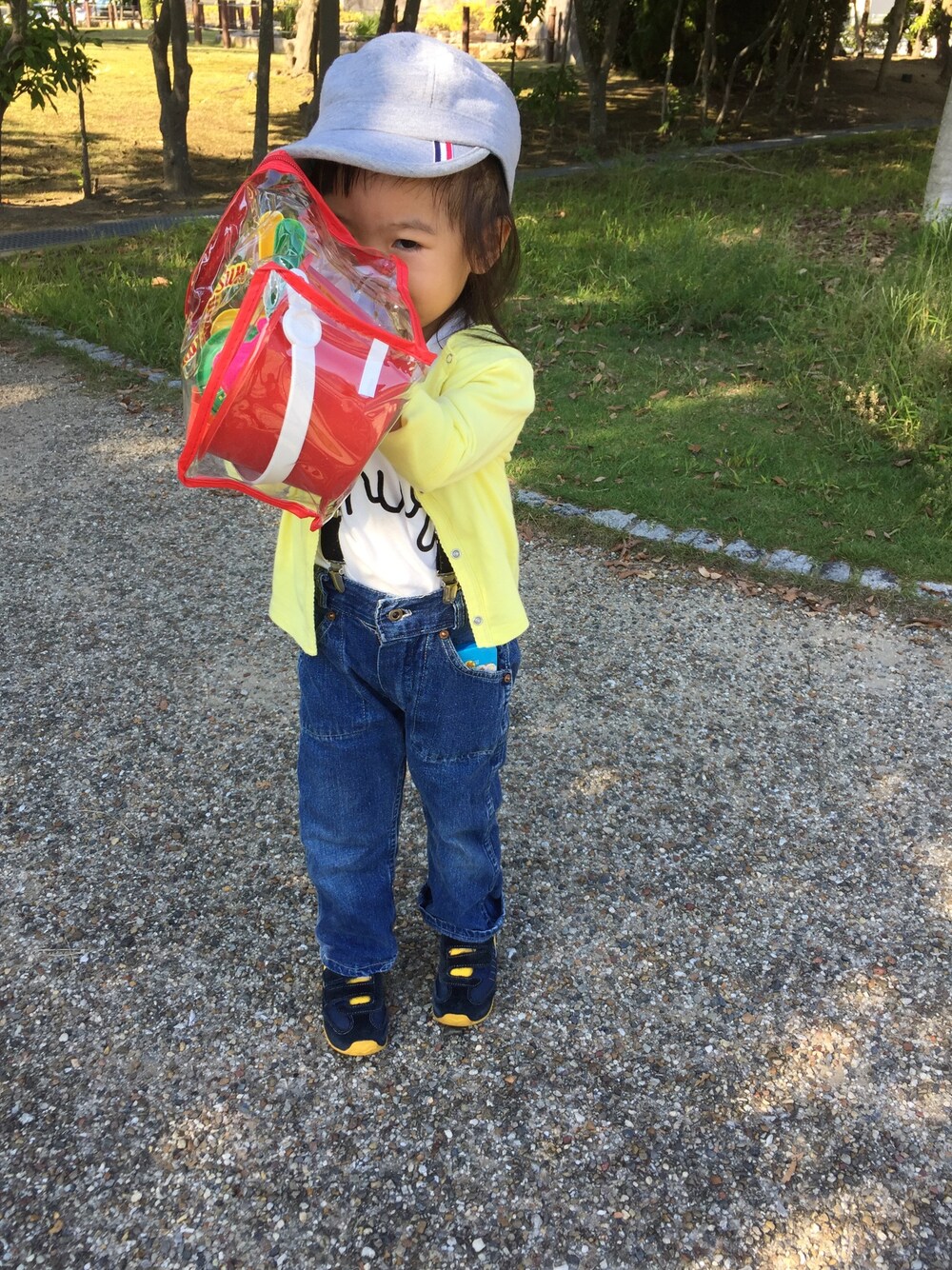 イエロー系のカーディガン/ボレロ、ブルー系のデニムパンツ、ブルー系のスニーカーを着用したキッズの秋コーディネートの1枚目の写真