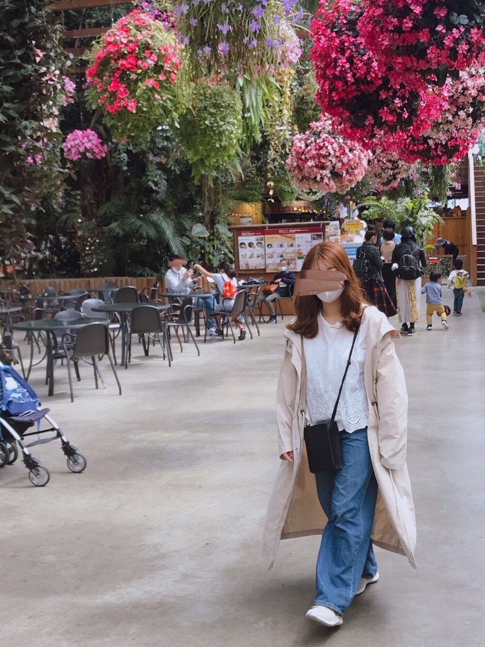 ベージュ系のスニーカー、ブルー系のデニムパンツ、ブラック系のショルダーバッグを着用したレディースの春コーディネートの1枚目の写真