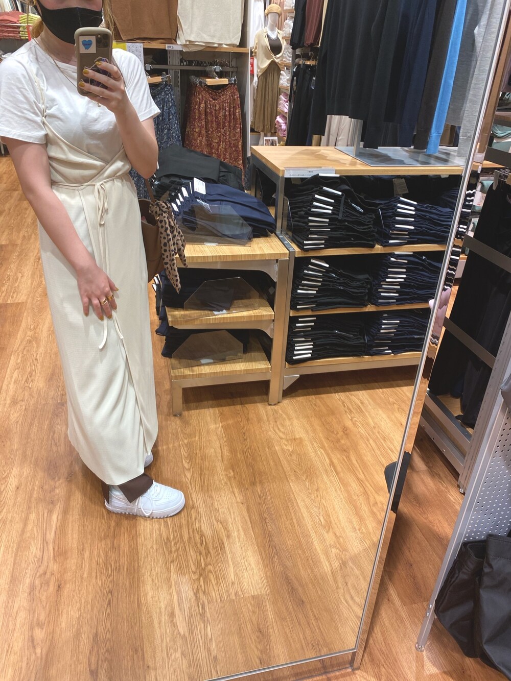 ホワイト系のワンピース、ブラウン系のスラックス、ホワイト系のスニーカーを着用したレディースの夏コーディネートの1枚目の写真