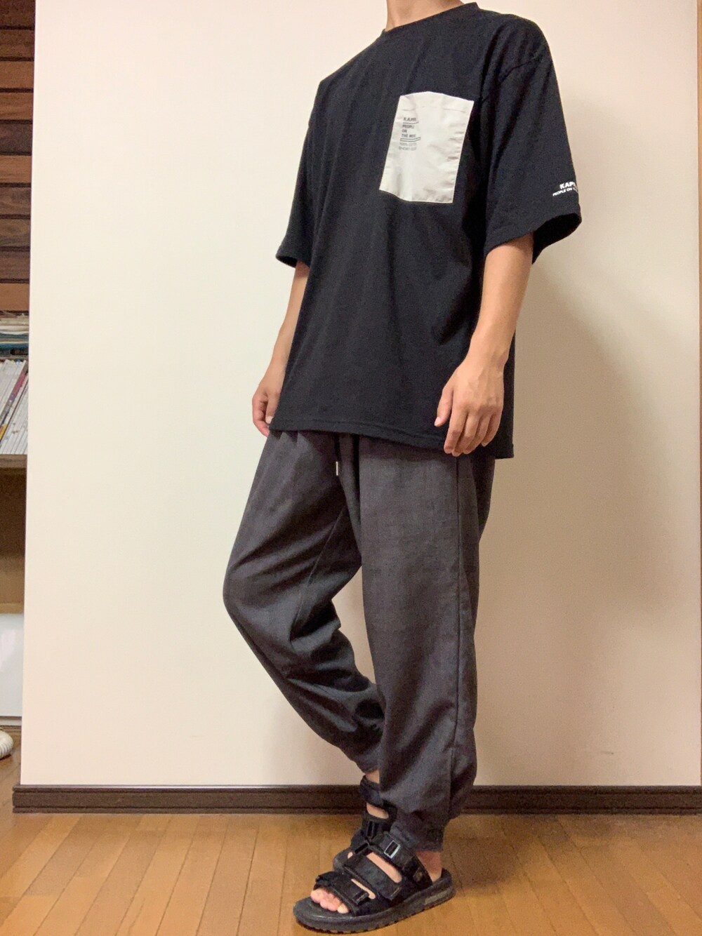 その他のその他パンツ、ブラック系のTシャツ/カットソー、ブラック系のサンダルを着用したメンズの秋コーディネートの1枚目の写真
