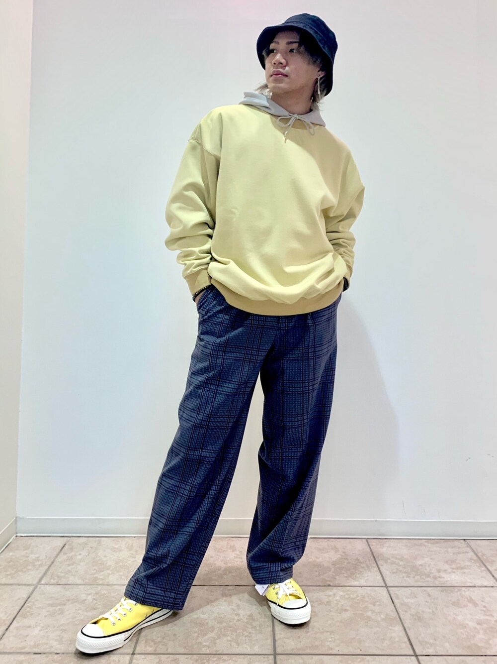 ベージュ系のパーカー、イエロー系のスウェット、グレー系のスラックスを着用したメンズの春コーディネートの1枚目の写真