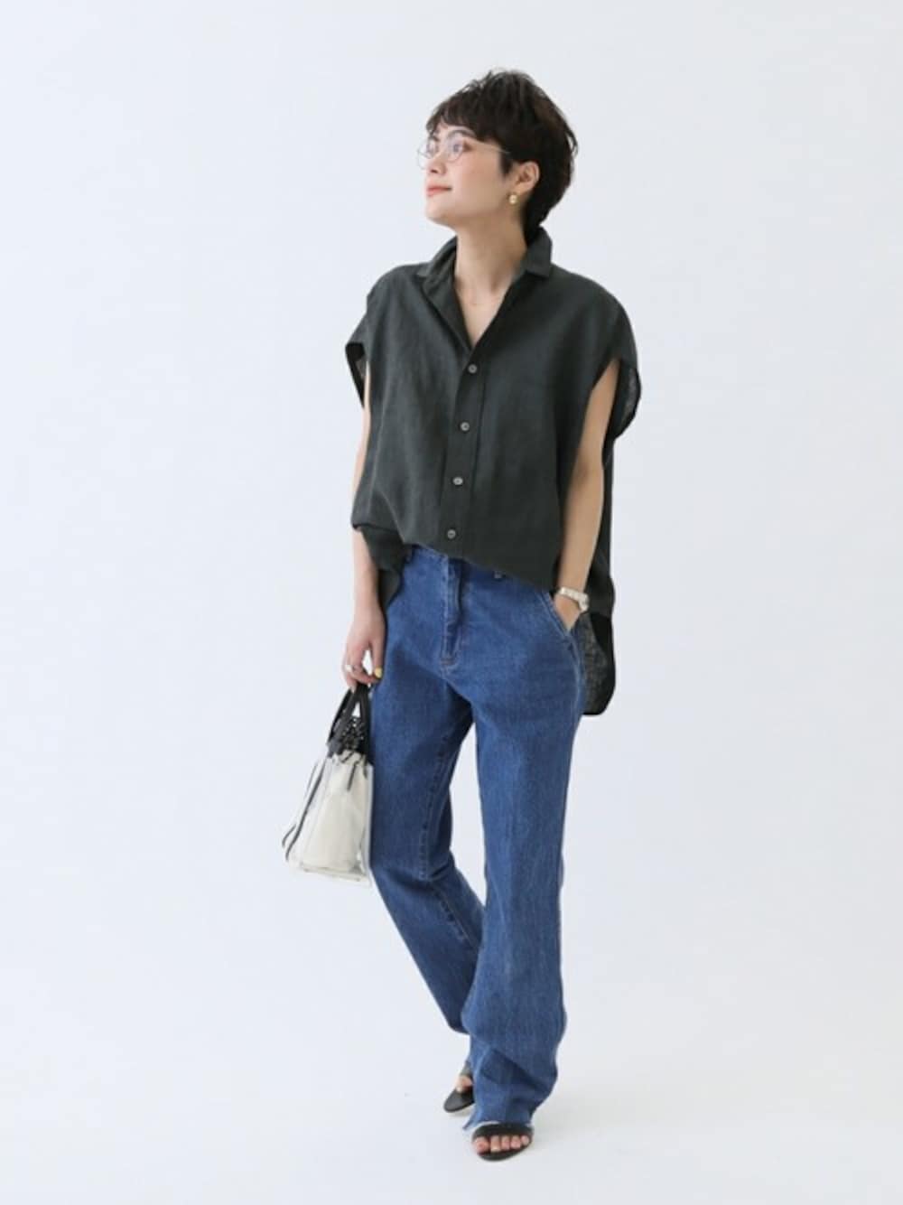 ブラック系のシャツ/ブラウス、ブルー系のデニムパンツ、ブラック系のショルダーバッグを着用したレディースの春コーディネートの1枚目の写真