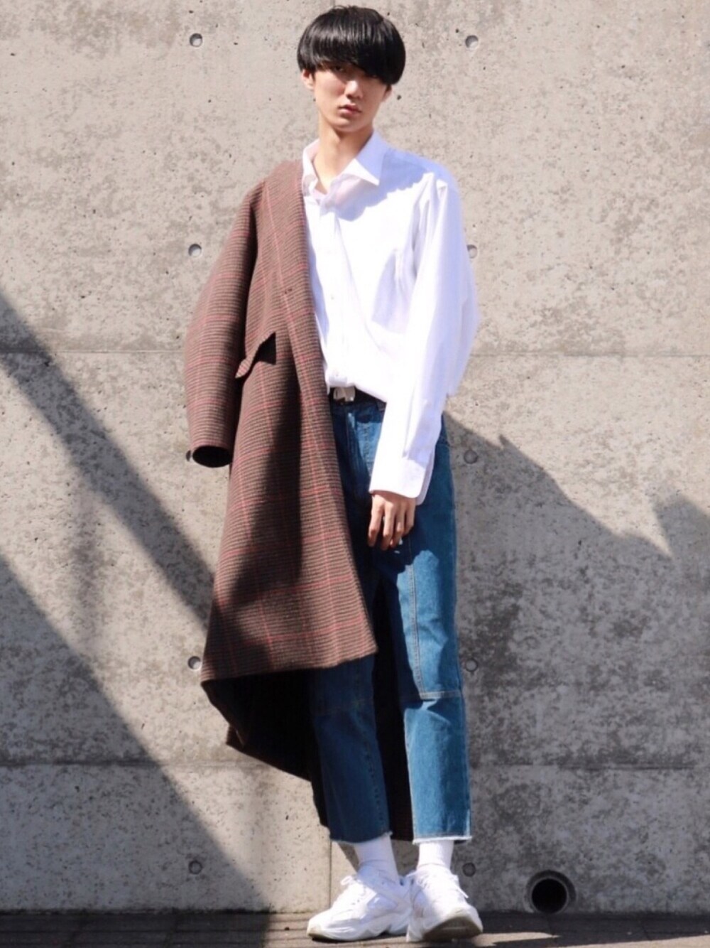 ブラウン系のチェスターコート、ホワイト系のシャツ/ブラウス、ブルー系のデニムパンツを着用したメンズの春コーディネートの1枚目の写真