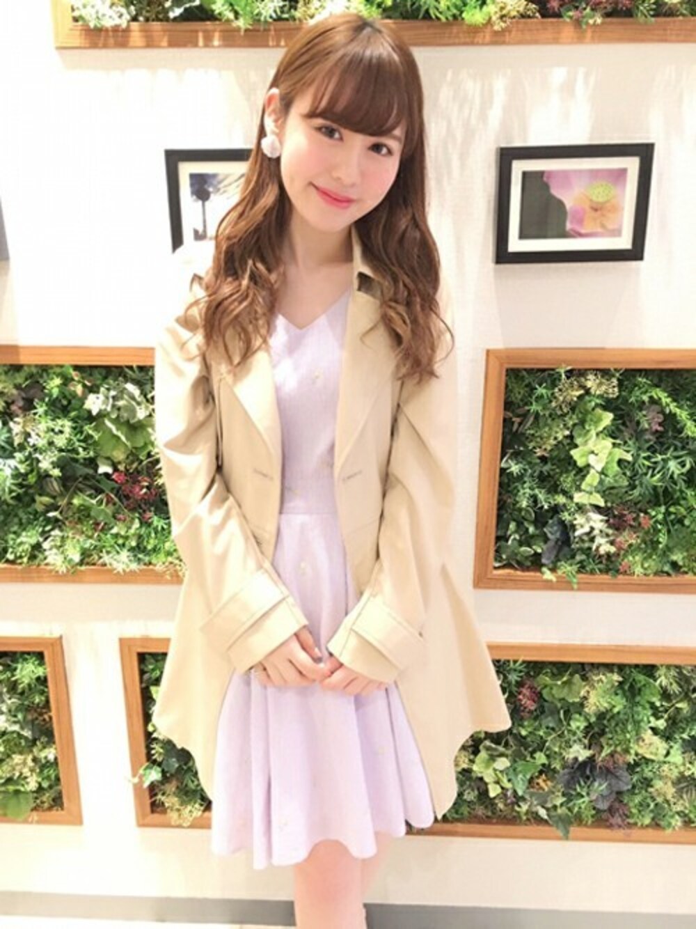 ベージュ系のトレンチコート、パープル系のワンピースを着用したレディースの春コーディネートの1枚目の写真