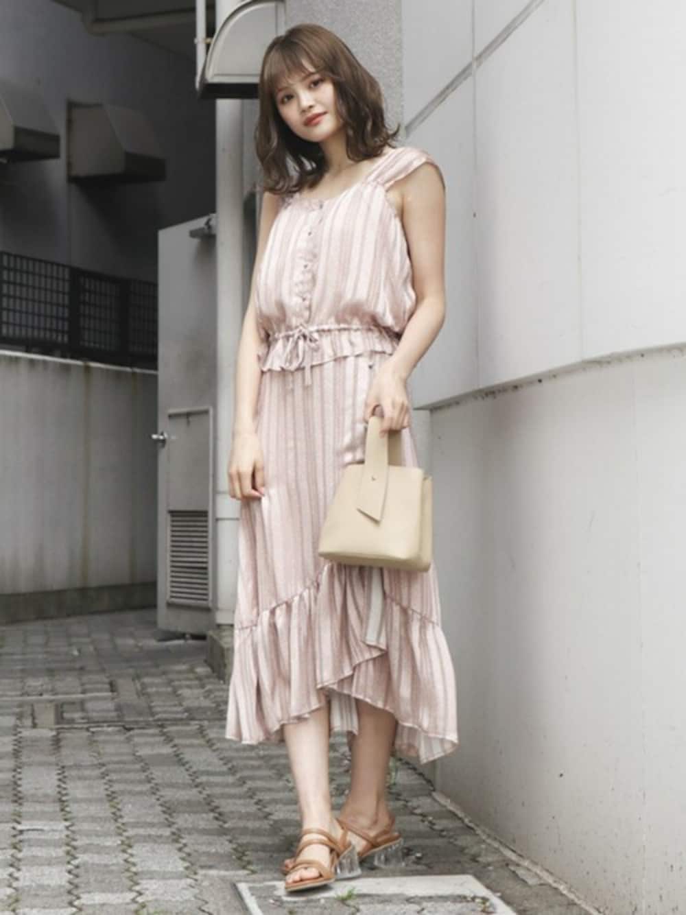 ピンク系のワンピース、ベージュ系のサンダルを着用したレディースの夏コーディネートの1枚目の写真