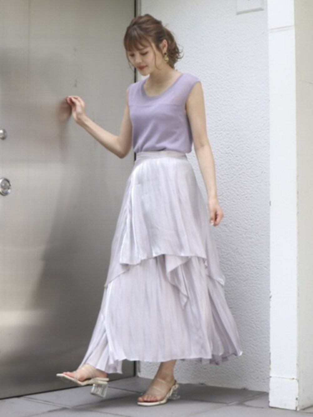 パープル系のニット/セーター、グレー系のスカート、その他のサンダルを着用したレディースの夏コーディネートの1枚目の写真