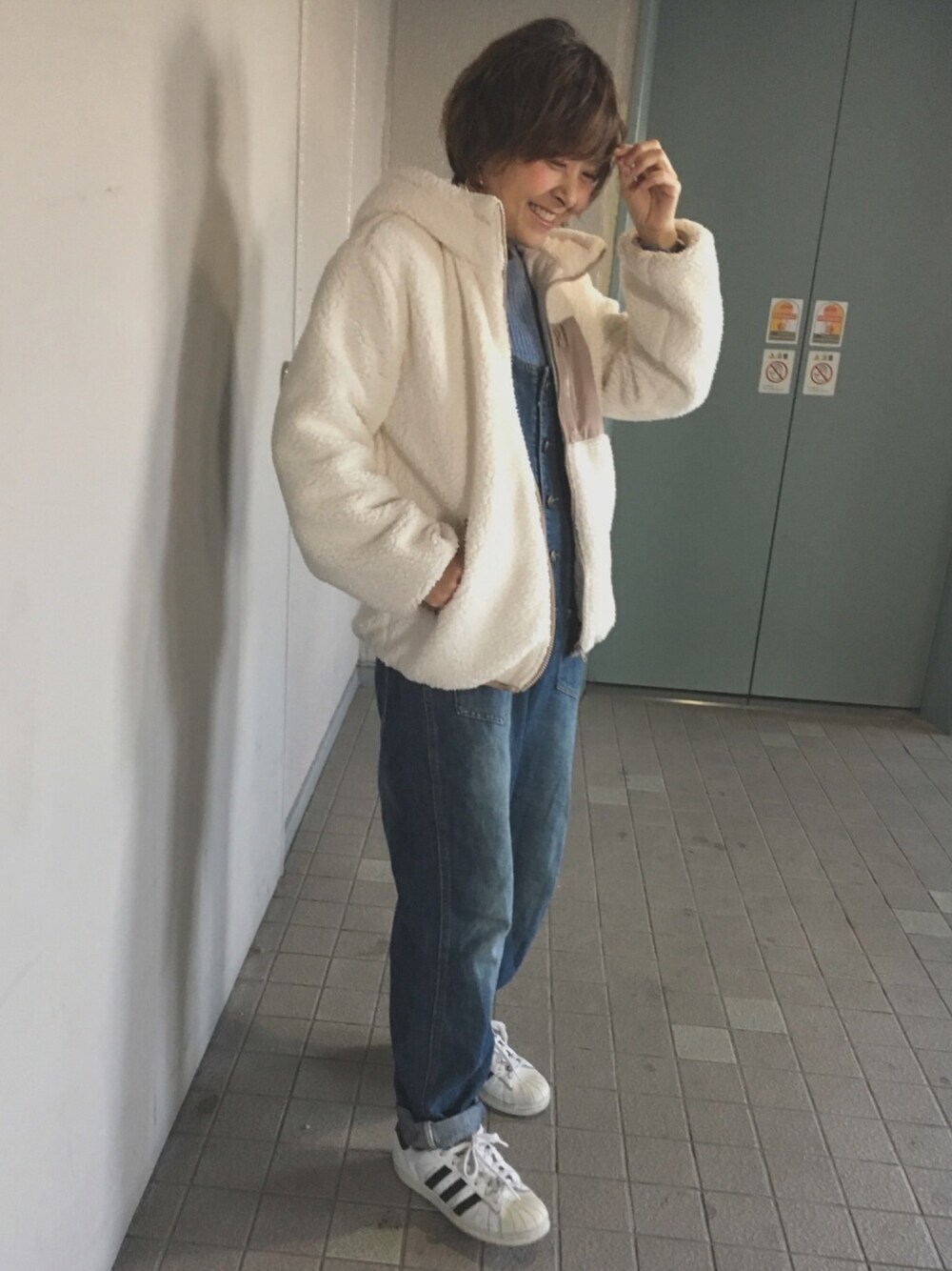 ホワイト系のブルゾンを着用したレディースの冬コーディネートの1枚目の写真