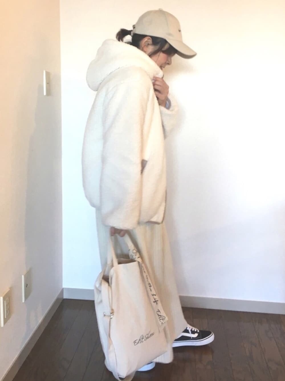 ブラック系のスニーカー、ホワイト系のトートバッグ、ホワイト系のブルゾンを着用したレディースの冬コーディネートの1枚目の写真