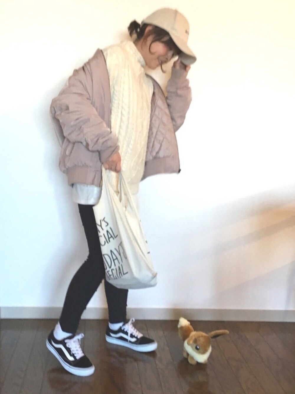 ホワイト系のニット/セーター、ホワイト系のエコバッグ/サブバッグ、ブラック系のスニーカーを着用したレディースの冬コーディネートの1枚目の写真