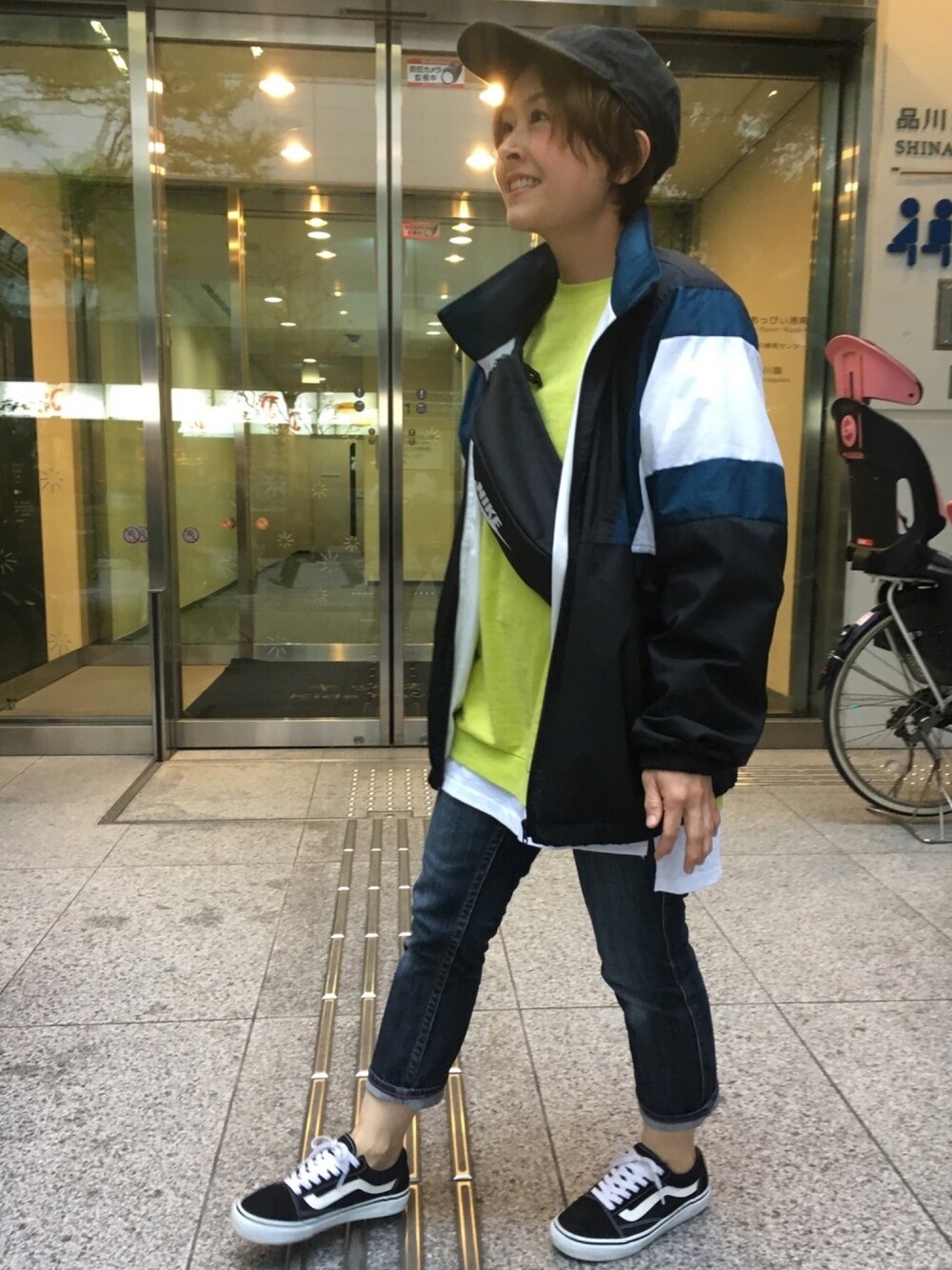 ブラック系のナイロンジャケット、グリーン系のスウェット、ブラック系のボディバッグ/ウエストポーチを着用したレディースの春コーディネートの1枚目の写真